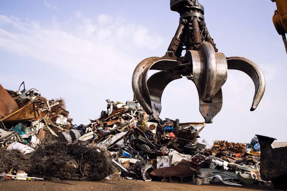 Industrial scrap metal pile with crane grab at recycling yard in Brisbane