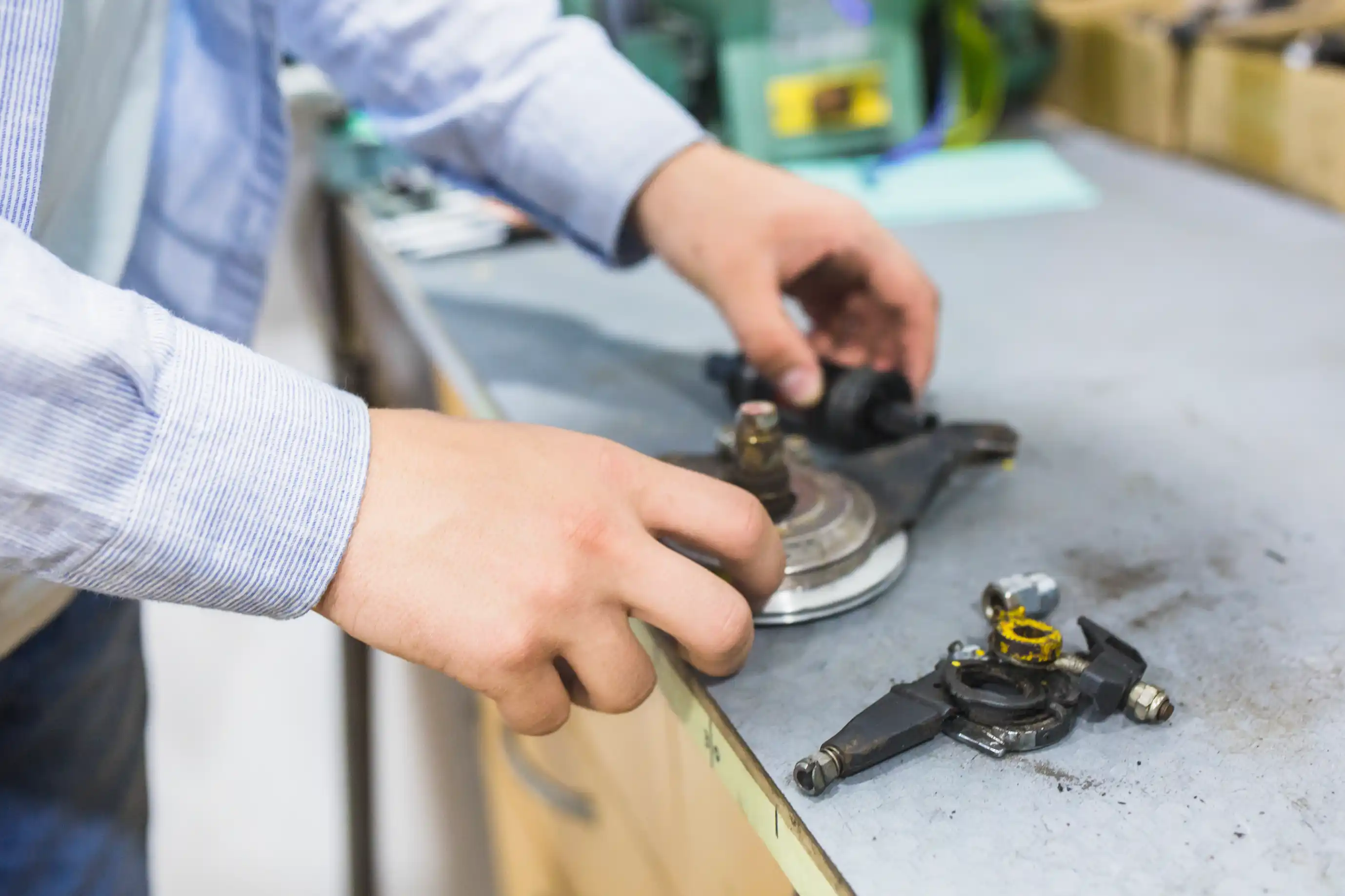 Close-up of a person's hands sorting used metal parts, nuts and bolts on a workbench